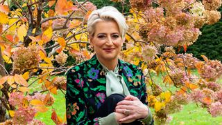 Dorinda Medley outside her Berkshires estate in the fall with colorful trees
