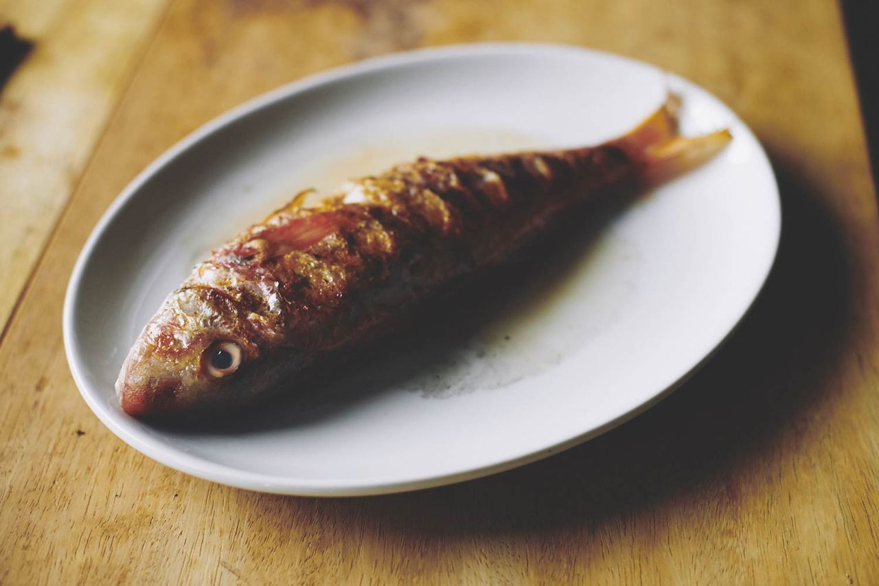 Whole cooked fish on a plate