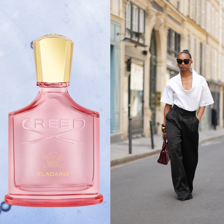 A woman wearing a white top and black pants next to a bottle of perfume. 