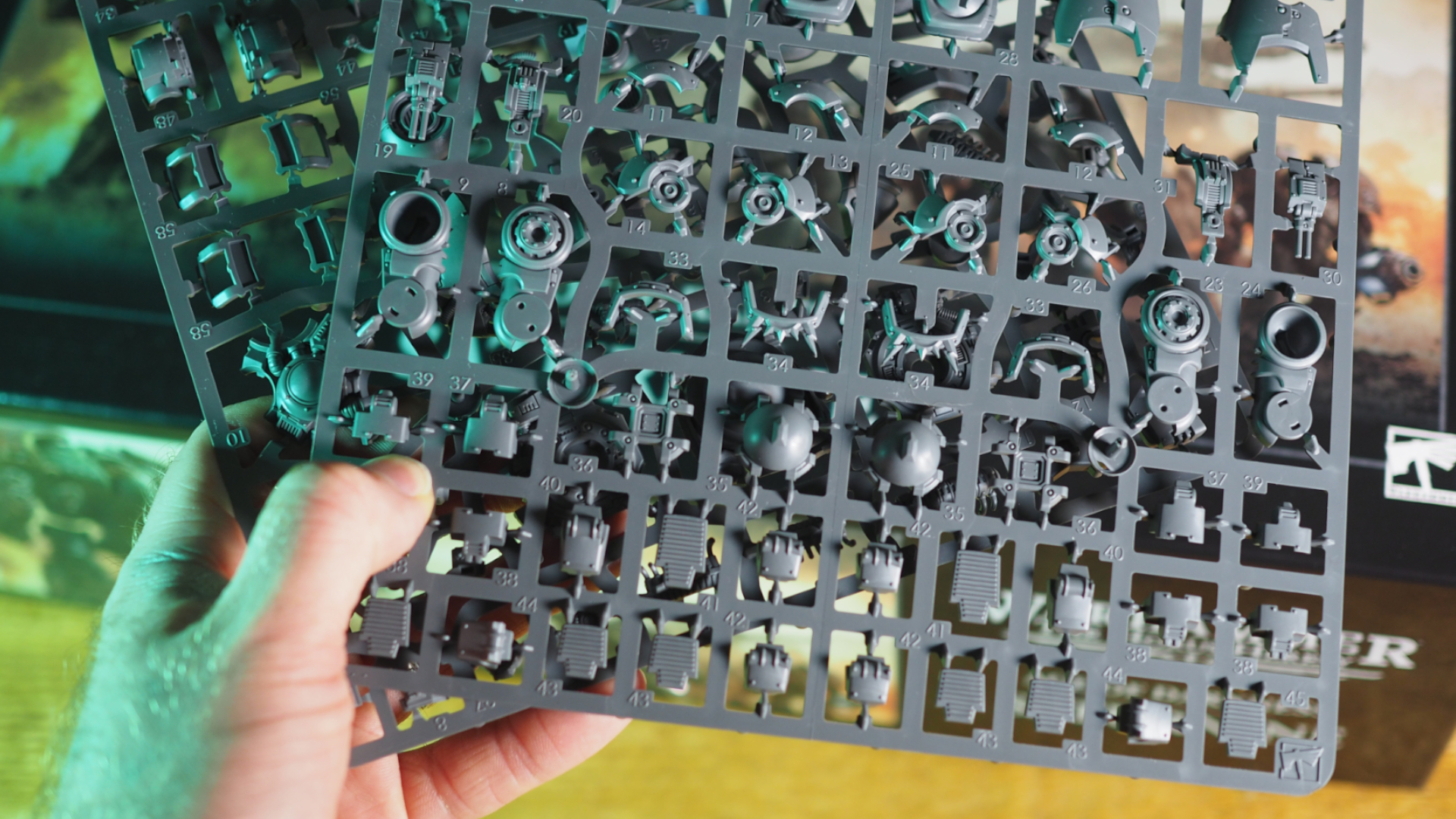 A hand holds plastic sprues from the Horus Heresy Saturnine box