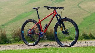 Cotic SolarisMAX bike pictured on a gravel track with grassy hills in the background