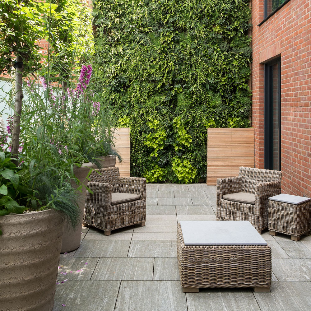 patio with wicker furniture and living wall