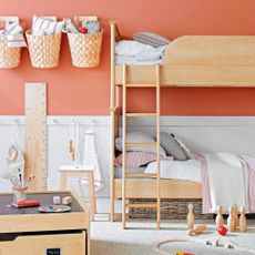 A childrens bedroom with a wooden bunk bed, wooden toy box and wooden skittles and toy train track in shot