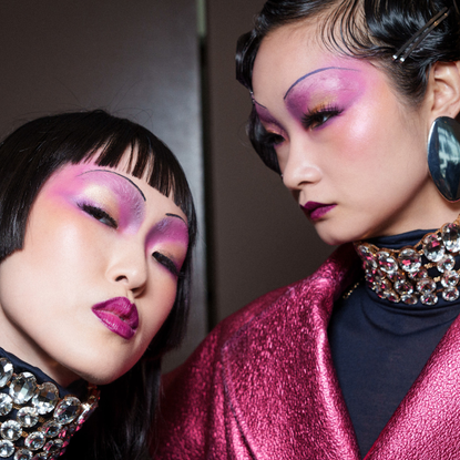 Two models wearing pink eyeshadow and posing