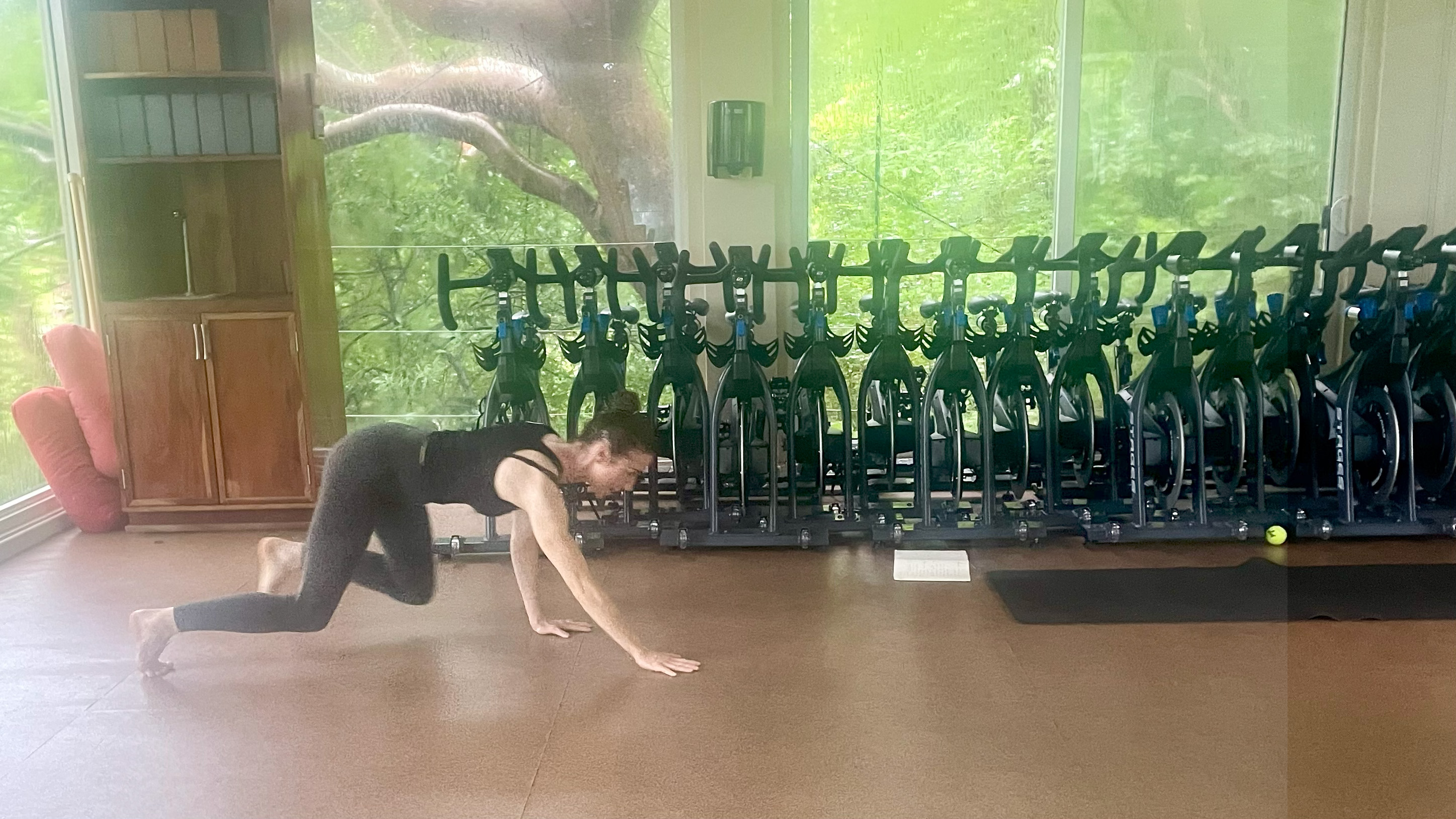 Lucy performing bear crawl in gym studio