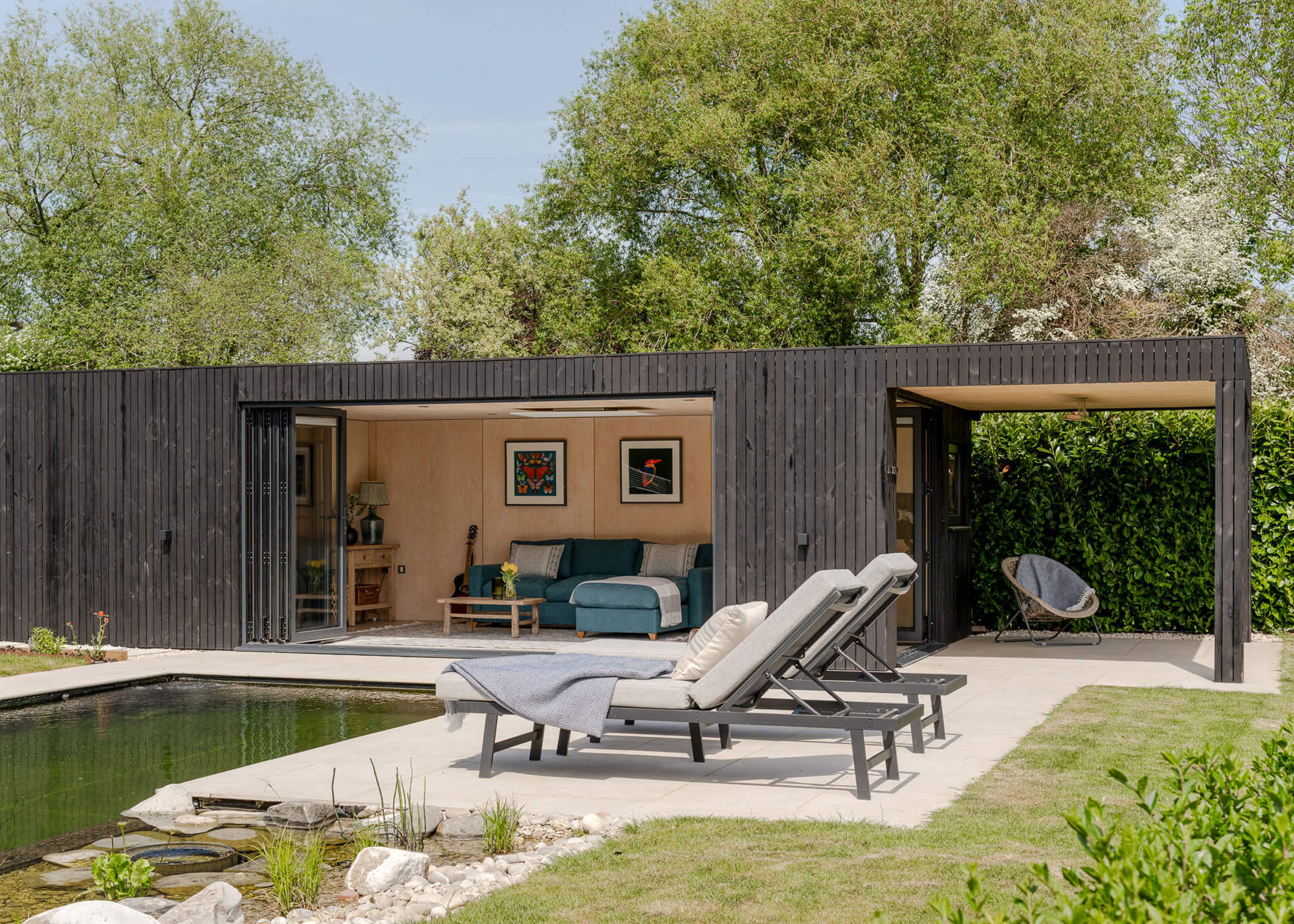 garden room with living room, pool and loungers, planting and lawn