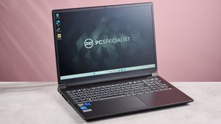 PC Specialist Defiance II 16 open on desk with pink background