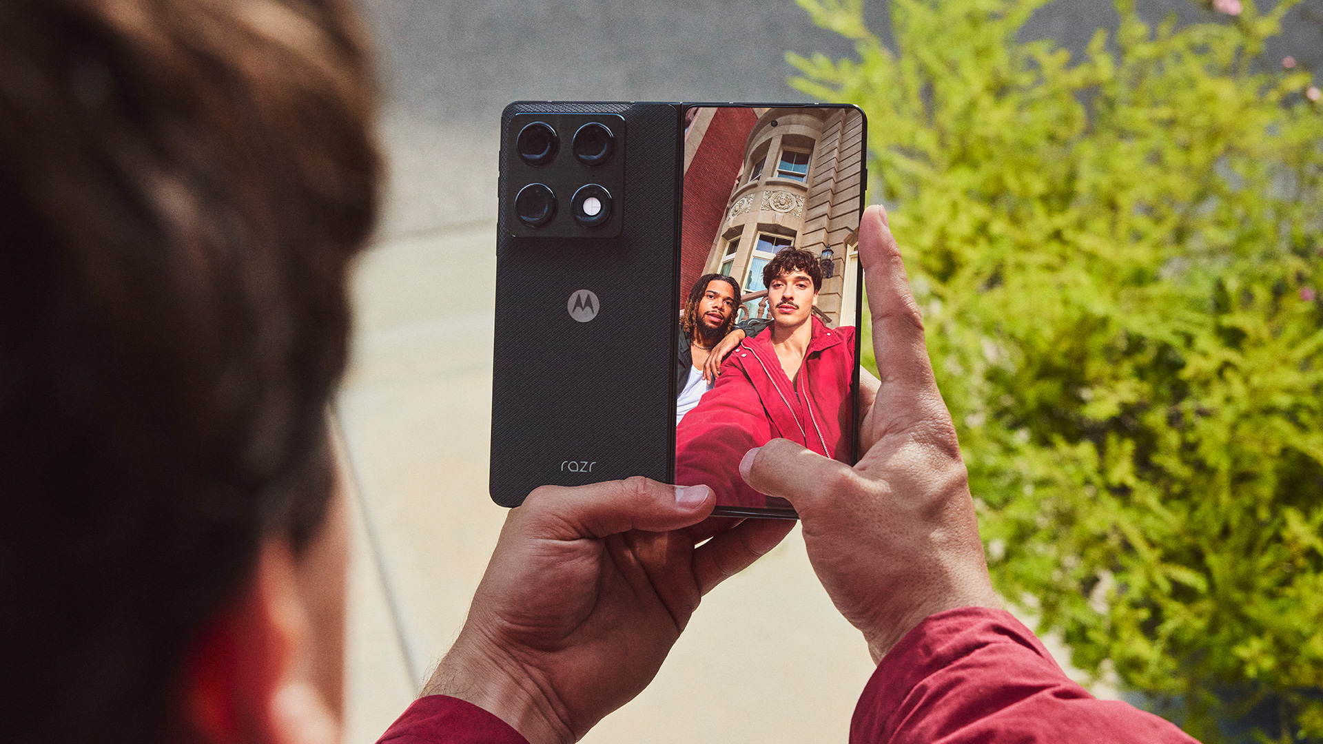 Man taking a selfie with his friend using Motorola Razr Fold's outer display and primary cameras