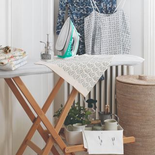 A laundry room with an ironing board