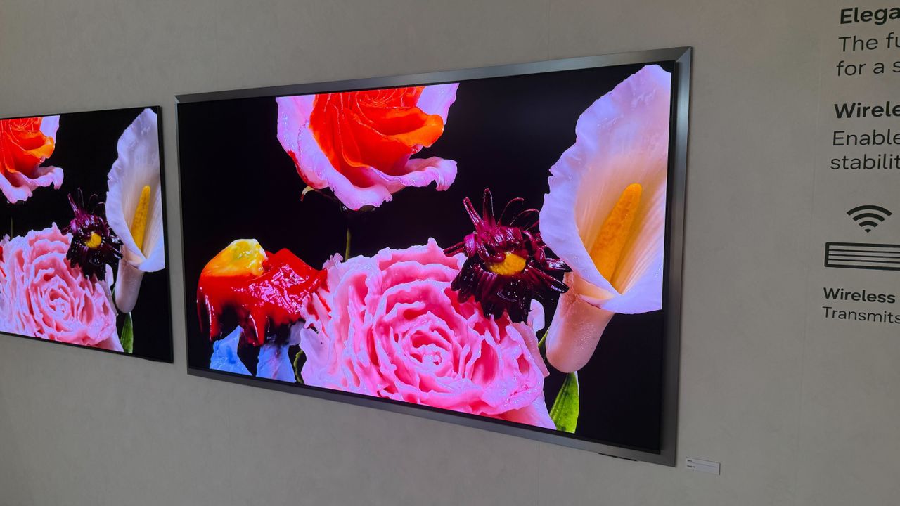 A wall mounted Samsung S95H with flowers on screen
