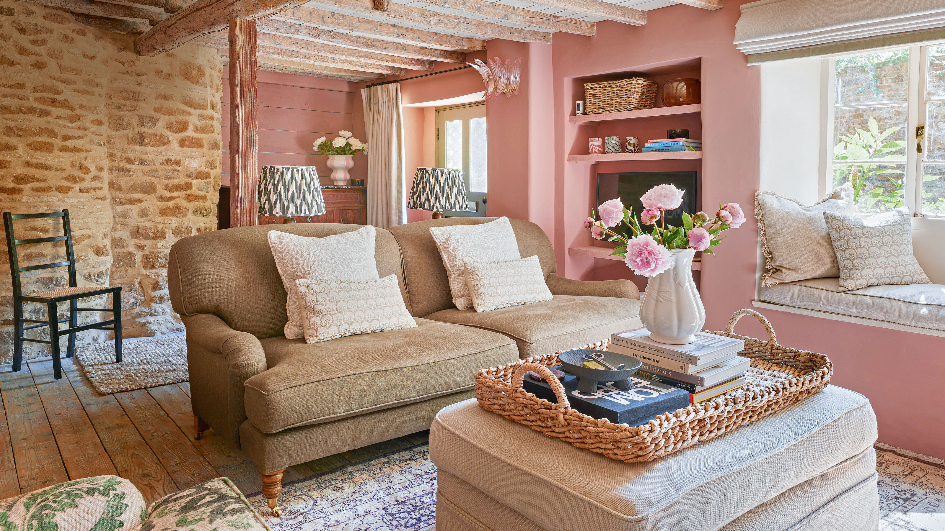 Pink living room with brown sofa and beige ottoman