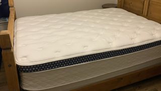 Image shows the WinkBed Mattress we slept on during our three-week testing period on a wooden bed frame