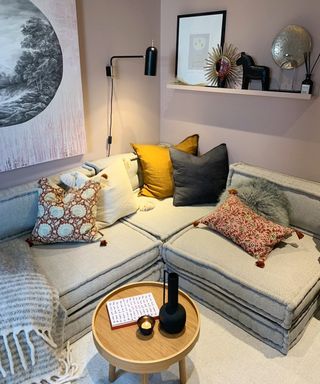 A small living room corner with grey floor cushions used as seating