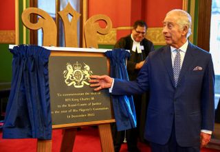 King Charles III unveils a plaque that commemorates his visit to The Royal Courts of Justice, Chancery Lane on December 14, 2023 in London