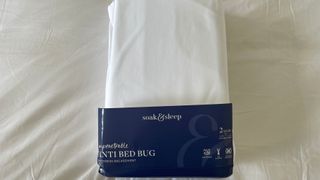 Soak & Sleep Anti-Bed Bug Mattress Encasement in its packaging, on the bed