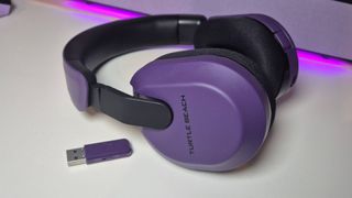 Photo taken by writer Rosalie Newcombe of the Purple Turtle Beach Stealth 600 Gen 3 wireless gaming headset, on a white desk.