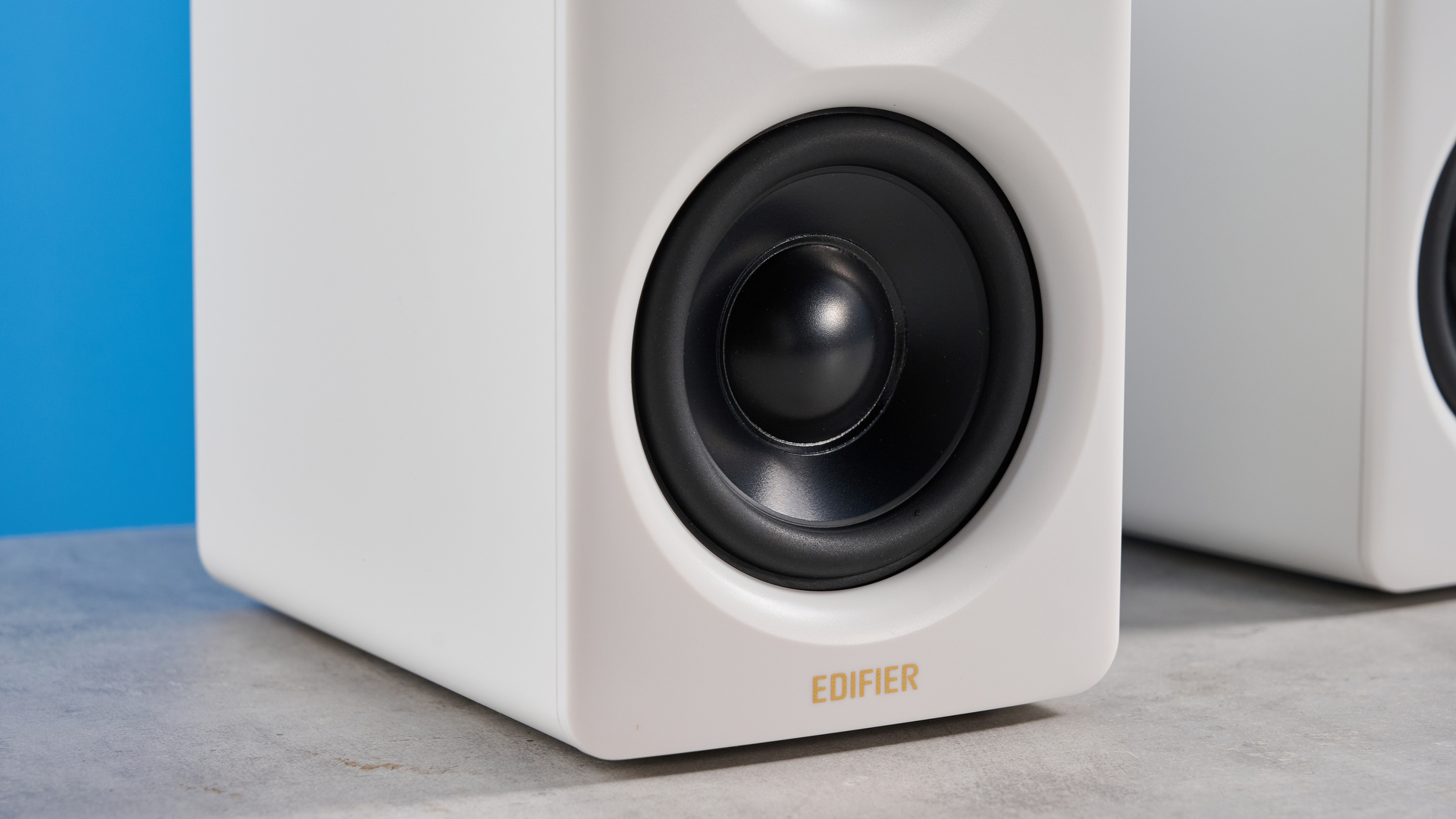 the edifier m60 bookshelf speakers in white photographed against the blue tom's guide background