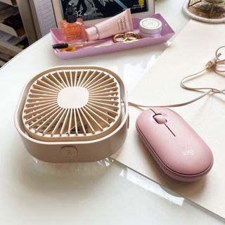 Small neutral desk fan on table