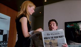 Iron Man Gwyneth Paltrow fixes up Robert Downey Jr as he reads the paper