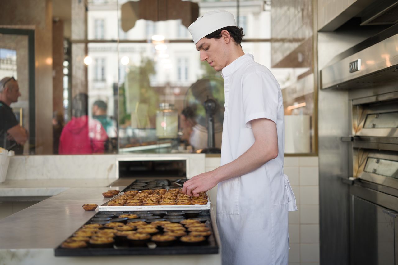 Sigma FP2 sample gallery: a worker removes custard tarts from trays taken out of an oven in a cafe