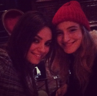Mila Kunis smiling, taking a selfie with friend