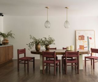 dining room with wooden table white walls and wooden credenza