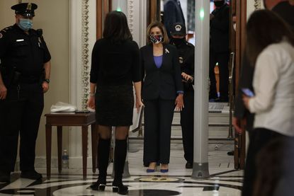 Nancy Pelosi walks through a metal detector