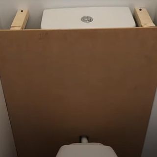 bathroom with wooden plyboard and commode