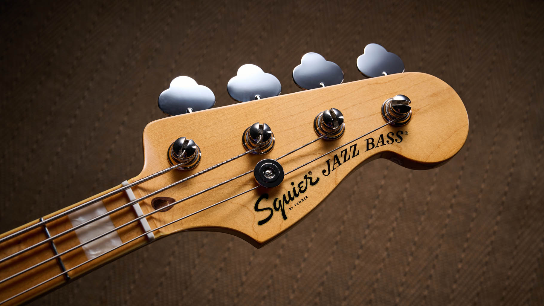 Squier Classic Vibe 70s Jazz Bass Active: finished in Ocean Turquoise, this keenly priced four-string is photographed in close-up with a patterned rug and wooden floor in the background.