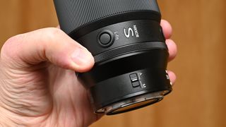 Nikon Z 35mm f/1.2 S product shot with lens held in hand