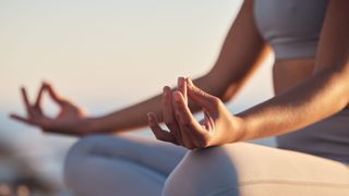 A woman meditating with her hands on her knees