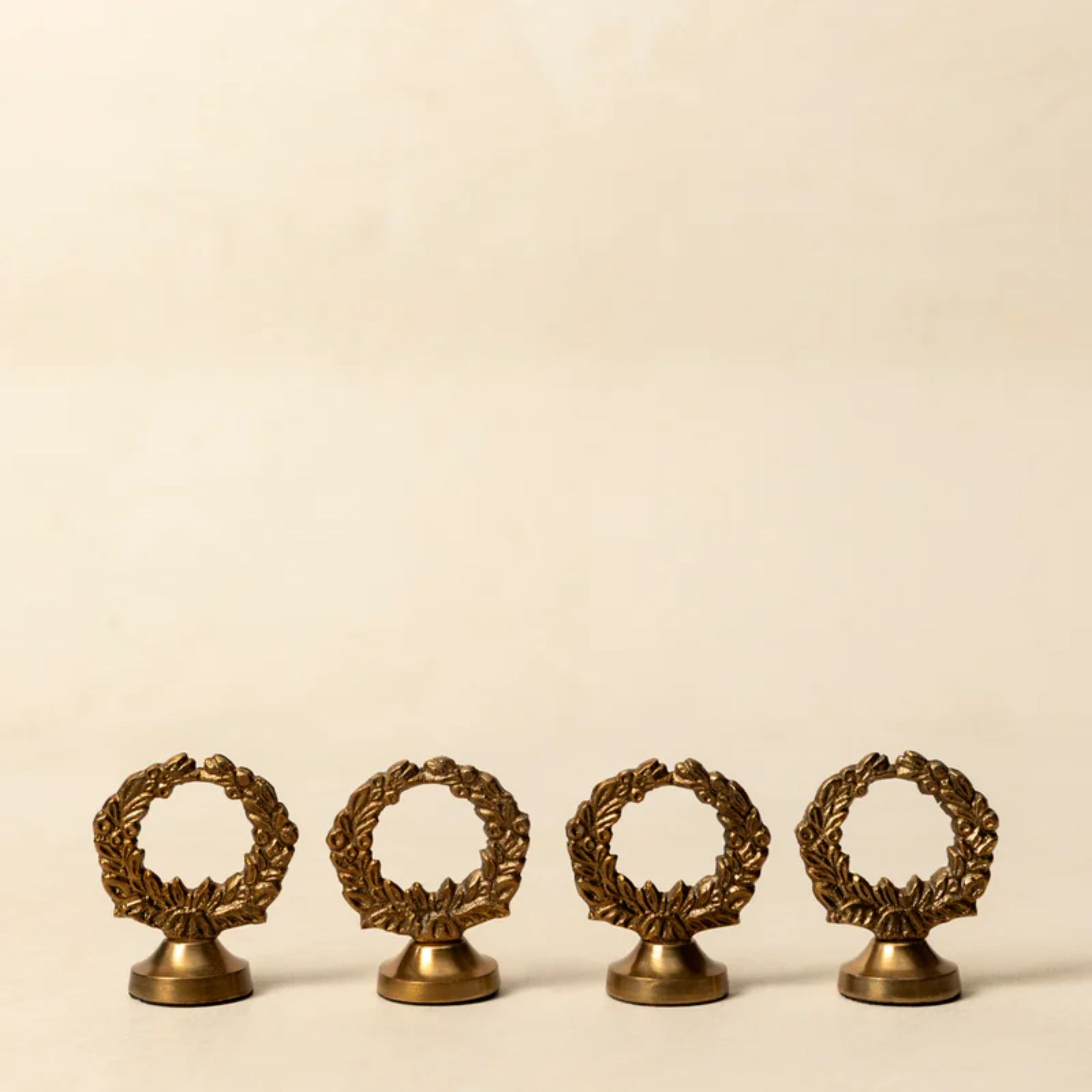 Wreath-shaped place card holders in antiqued brass
