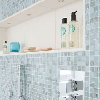 shower storage ideas with blue mosaic tiles and alcove storage
