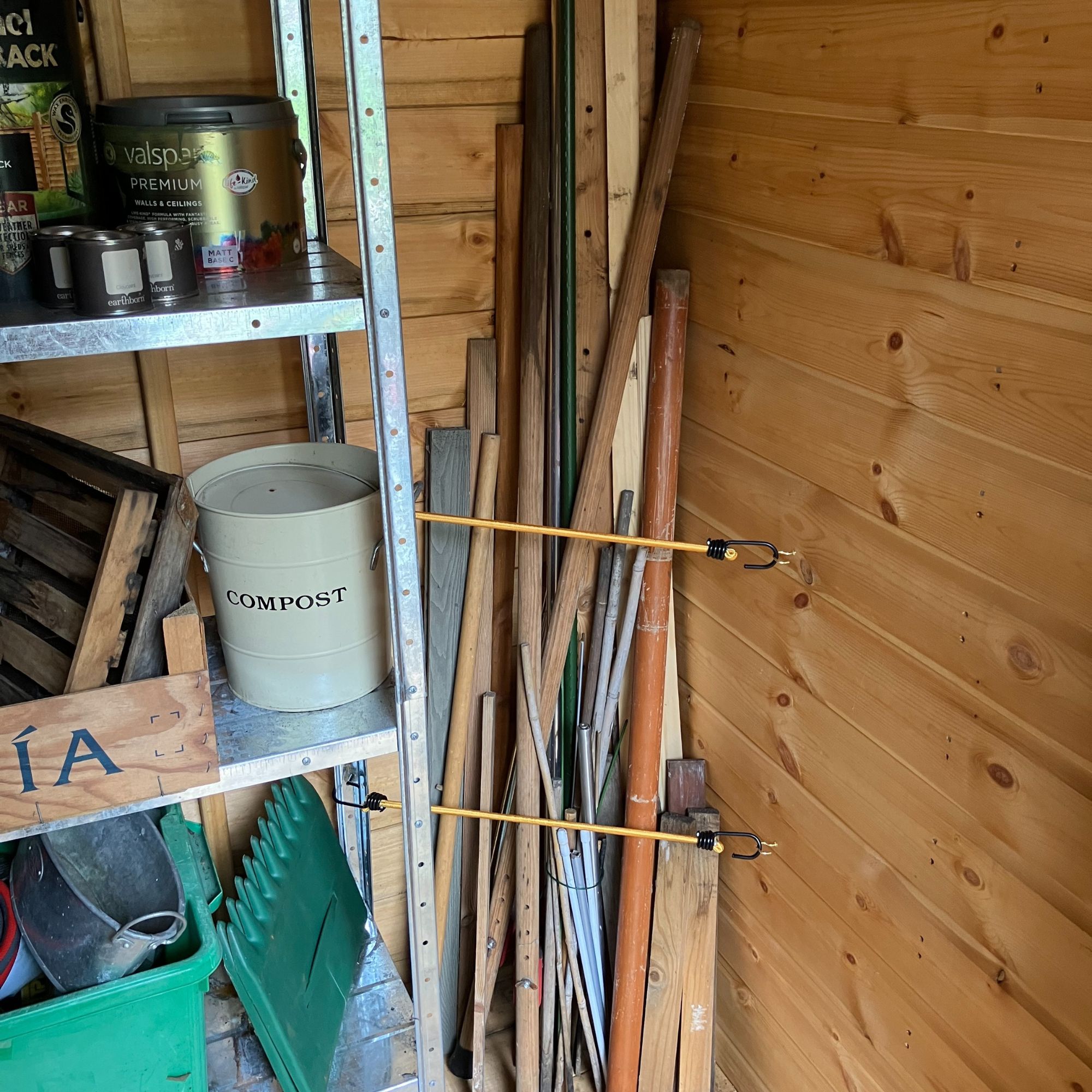 bungee cord shed storage with wooden poles in corner