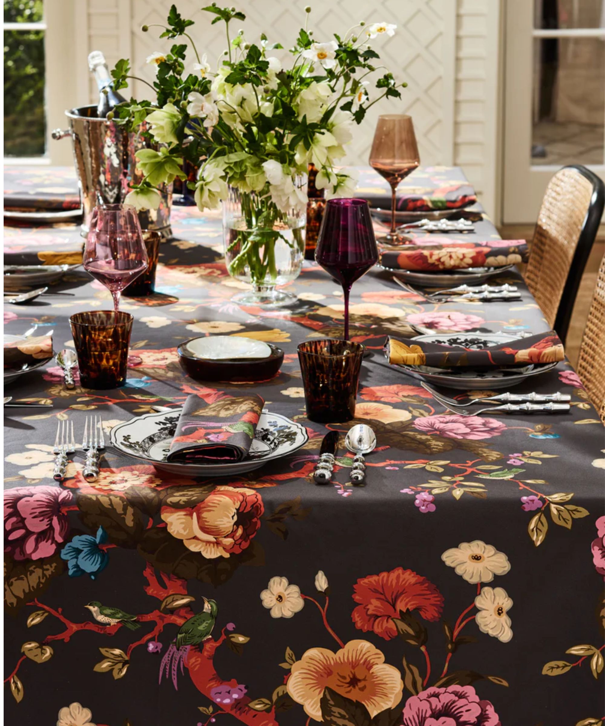Black floral tablecloth with matching napkins and pink glassware