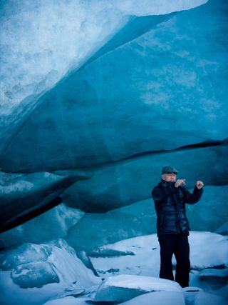 composer Ryuichi Sakamoto standing in a glacier