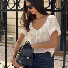 A French woman wearing a white top and jeans