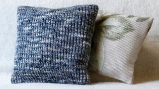 Two cushions, one which has a cover made from an old jumper