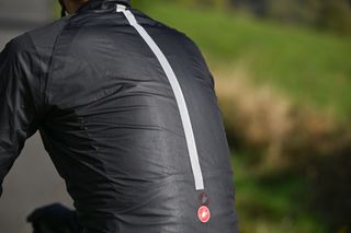 Rear view of a man wearing the Castelli Squall Shell jacket in black