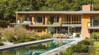 A contemporary self build property with a large and sleek rectangular pool with ornamental grasses