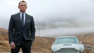 Daniel Craig in Skyfall standing next to a car.