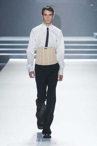 Man on Dolce & Gabanna runway in corset white shirt and black trousers