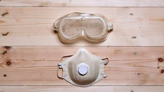 dust mast and googles covered in dust on planks of wood