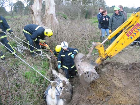 The digger goes to work removing the side of the ditch