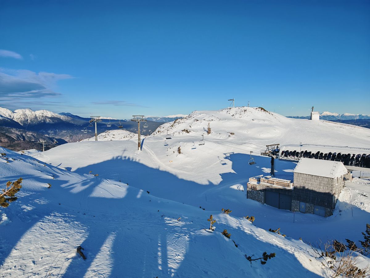 A series of ski lifts going across snowy mountains