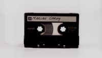A cassette tape with 'Mariah Carey' written on it.