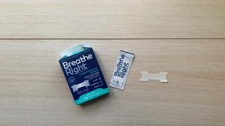 A package of Breathe Right nasal strips with one open, next to it