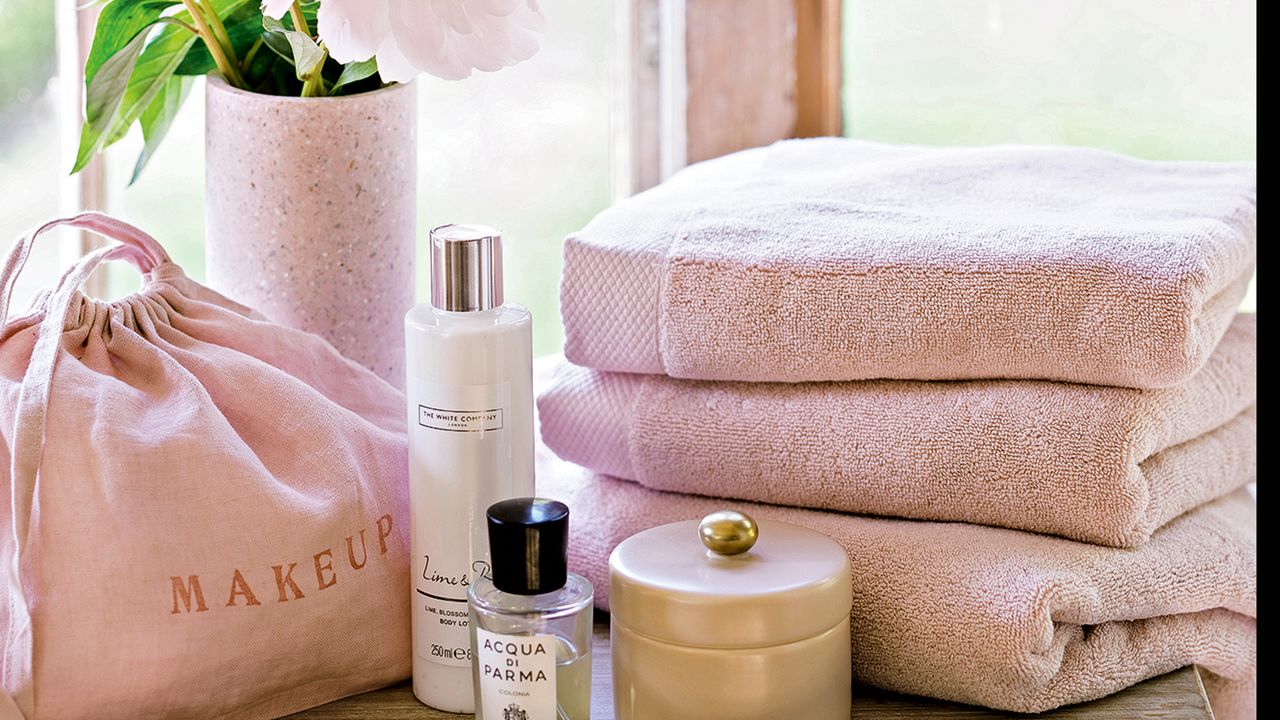 Stack of pink fluffy towels in front of a wooden window