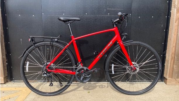 A Trek FX 2 Disc Equipped pictured in front of a black door