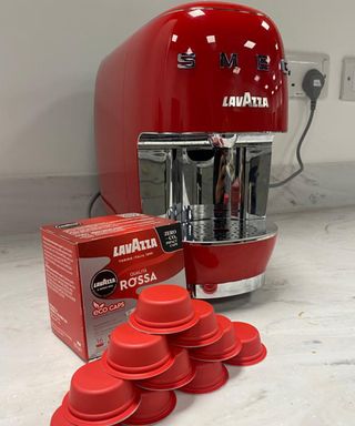 Smeg Lavazza A Modo Mio pod coffee machine with stacked Rosso coffee capsules